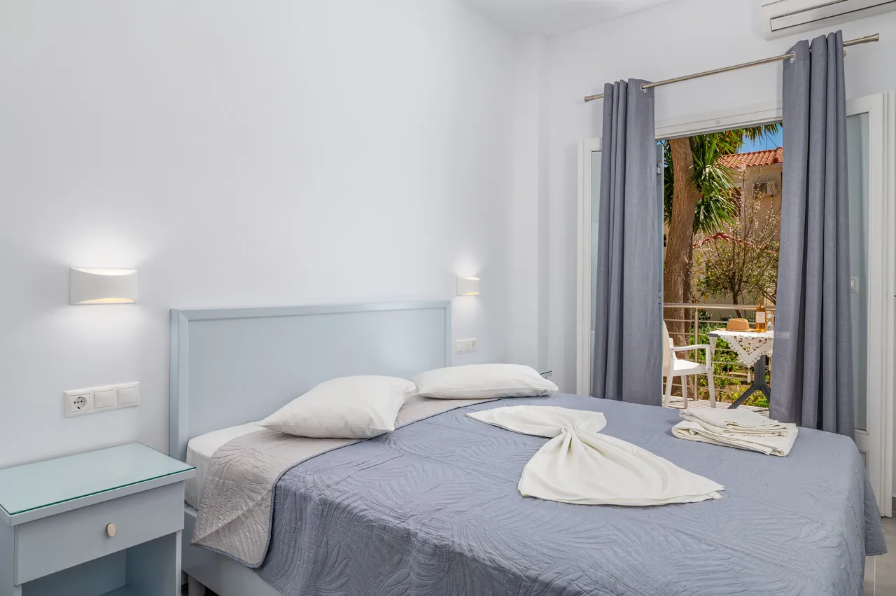 Bedroom in an apartment with a balcony door open to the garden