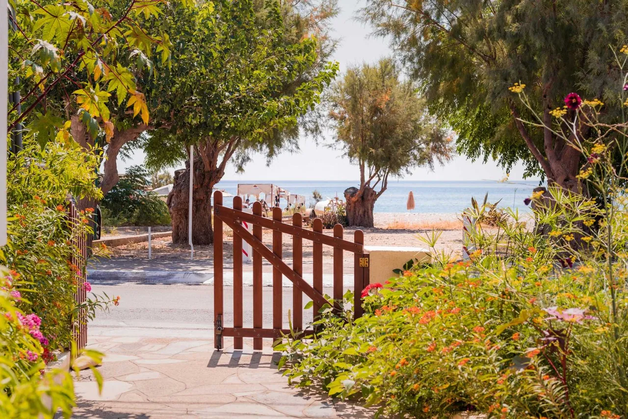 Wooden garden gate open towards the road and the sea